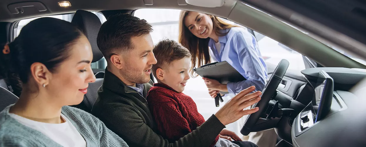 Family looking at the interior of a new Porsche vehicle