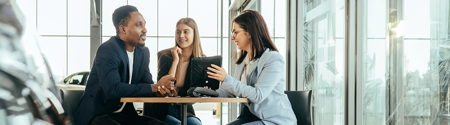 couple looking at a tablet with a sales woman