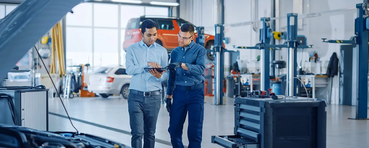 Automotive service advisor reviewing vehicle maintenance and repair recommendations with a customer in a professional service center