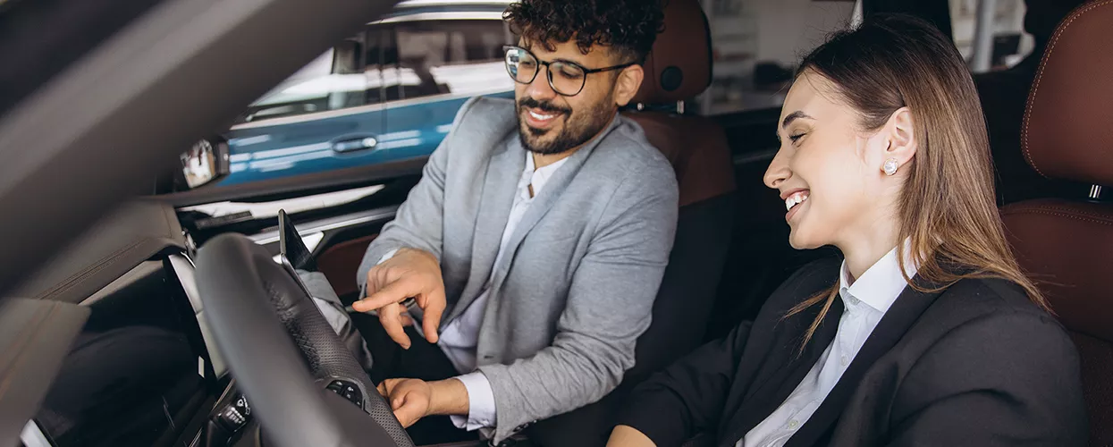 Car salesman showing a customer the interior of a vehicle