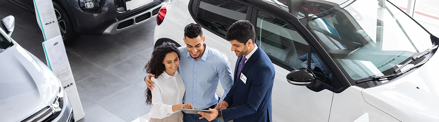 Car salesperson showing information about a Honda vehicle to customers on a tablet