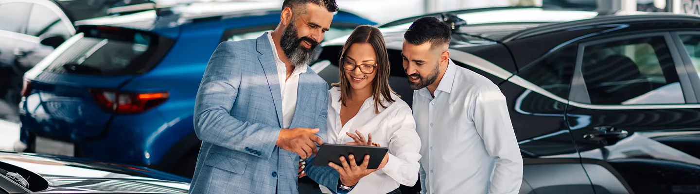 Customers looking at information on a tablet with a salesperson