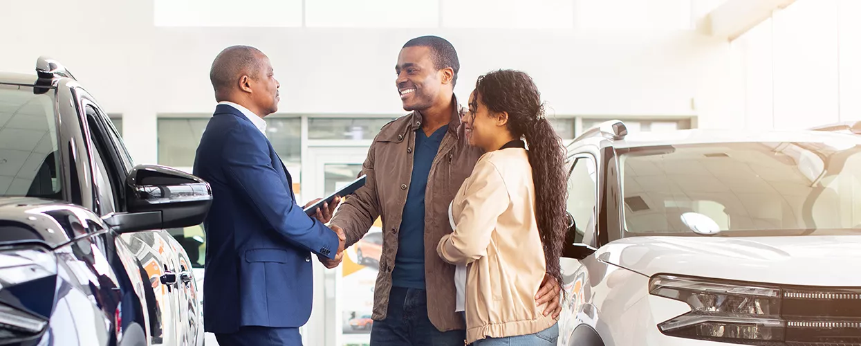 Car salesman showing a new car to a couple