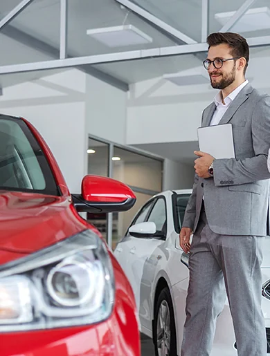 Two men in suits stand beside a luxury car, exuding professionalism and confidence.