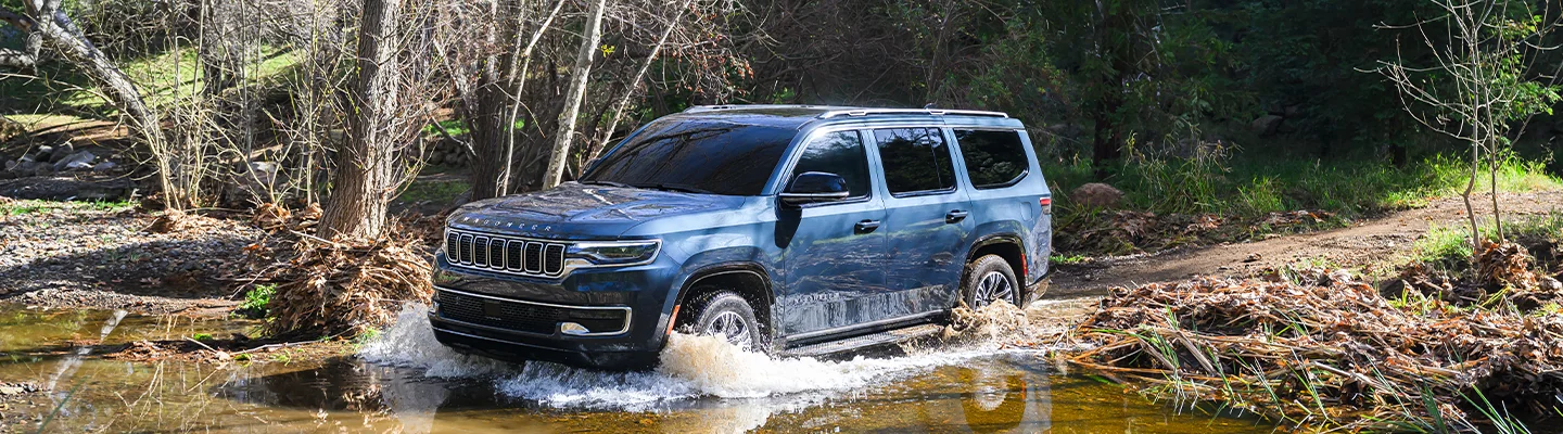Jeep Wagoneer driving through a puddle
