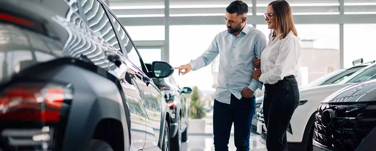 Couple looking at a new vehicle in a car dealership