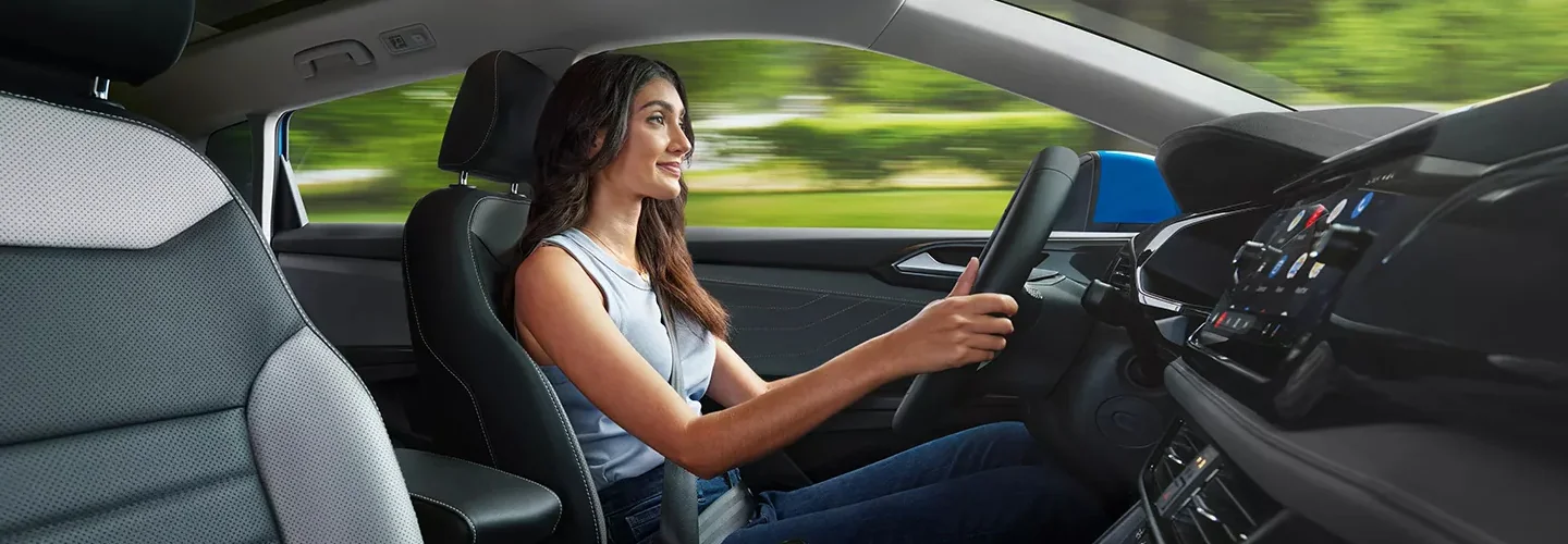 Interior view of the front seat with a women driving in a 2024 Volkswagen Taos