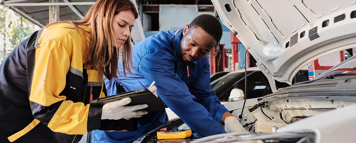 Service technician working on a Ford vehicle in a dealership service bay