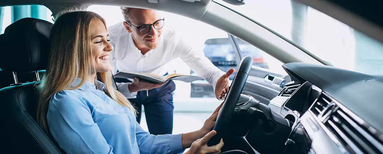 Car salesman showing a customer the interior of a vehicle