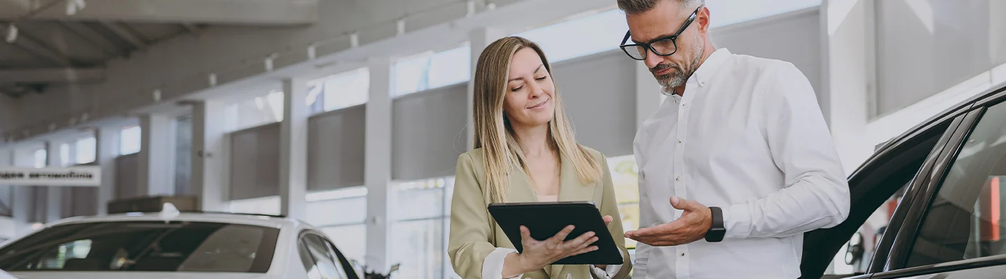 a person looking over details of a Lexus puchase with salesperson