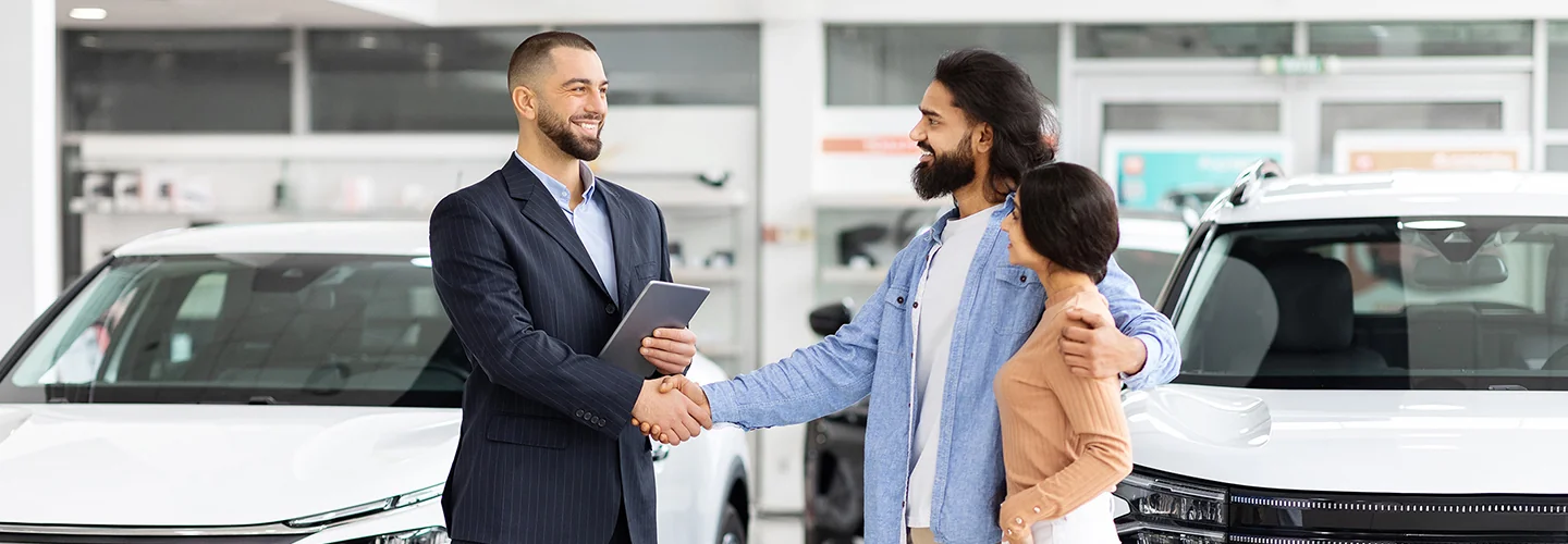 couple speaking with car sales person in the dealership