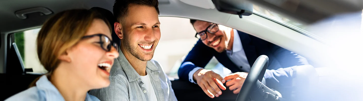 Salesman showing customers the interior of a vehicle