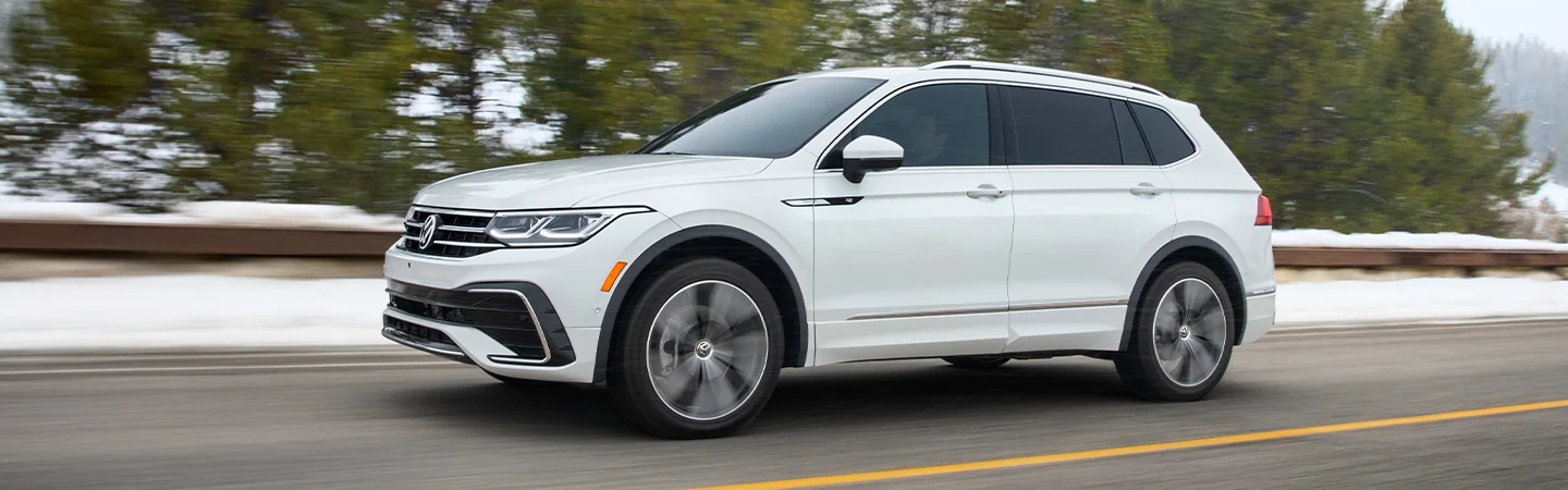 white 2025 Volkswagen Tiguan SEL R-Line driving on road with snow on side