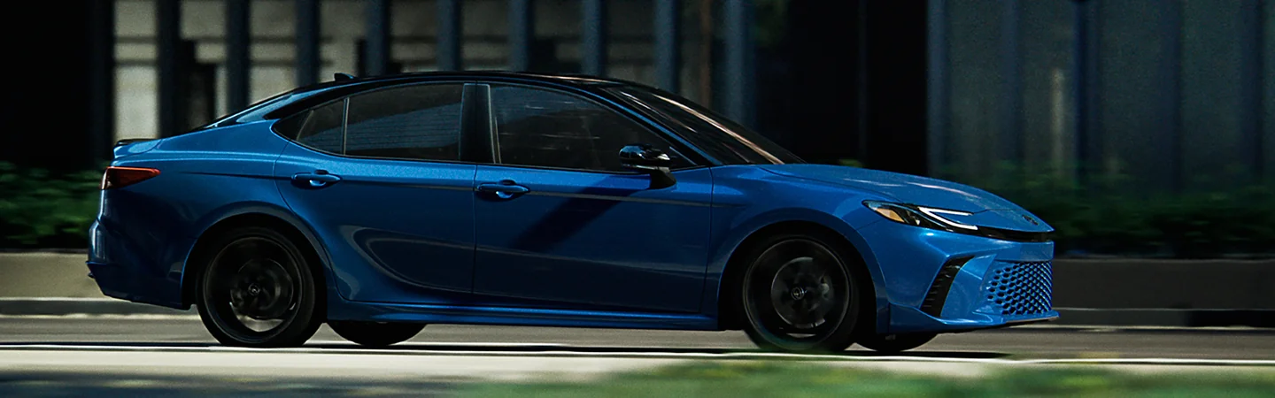 Front view of 2025 Toyota Camry driving down a road
