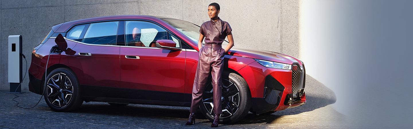 A driver standing outside of their BMW iX