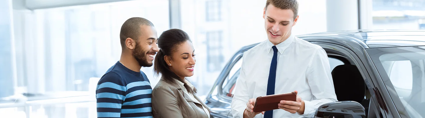 Car salesperson showing information to customers on a tablet