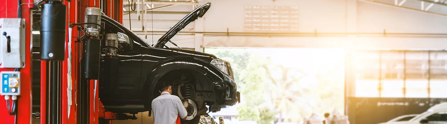 an auto mechaninc working on car on a lift