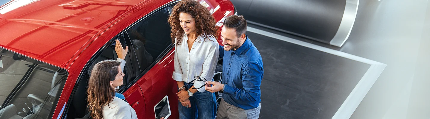 people shopping in car showroom lot