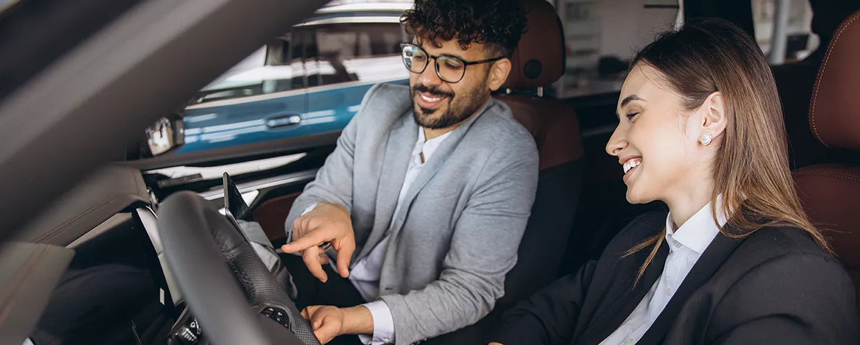 Car salesman showing a customer the inside if a new vehicle