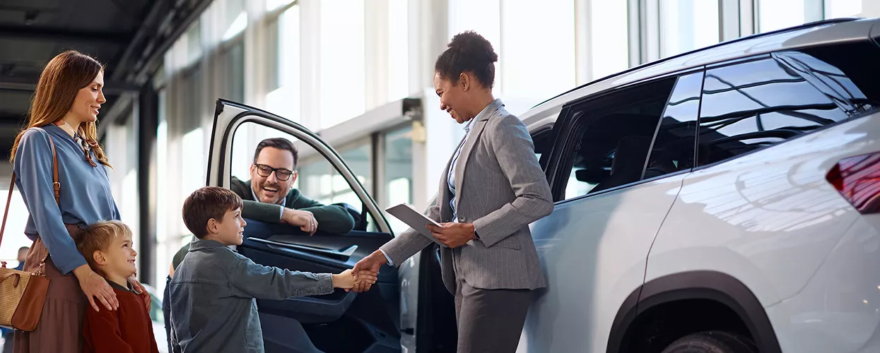 Car saleswoman talking to a family about a new vehicle