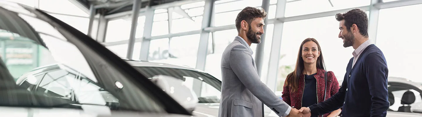 two people shaking hands making a new car deal