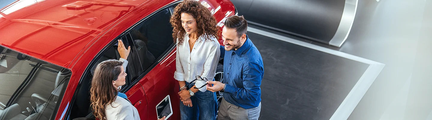 Car salesperson showing a vehicle to customers