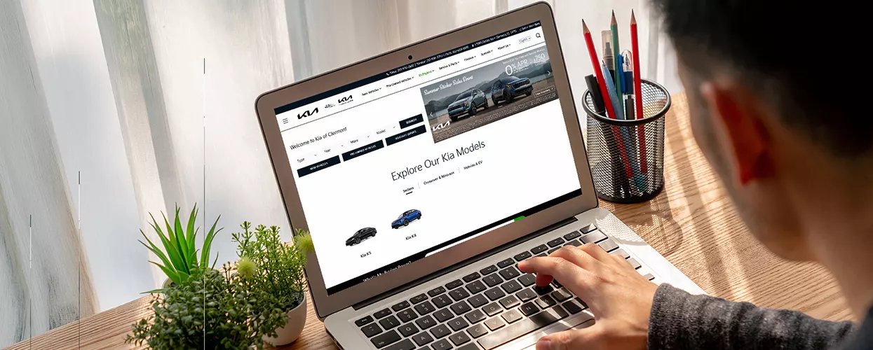 Customer browsing a dealership website on a laptop to explore vehicle inventory, model information, and online shopping tools