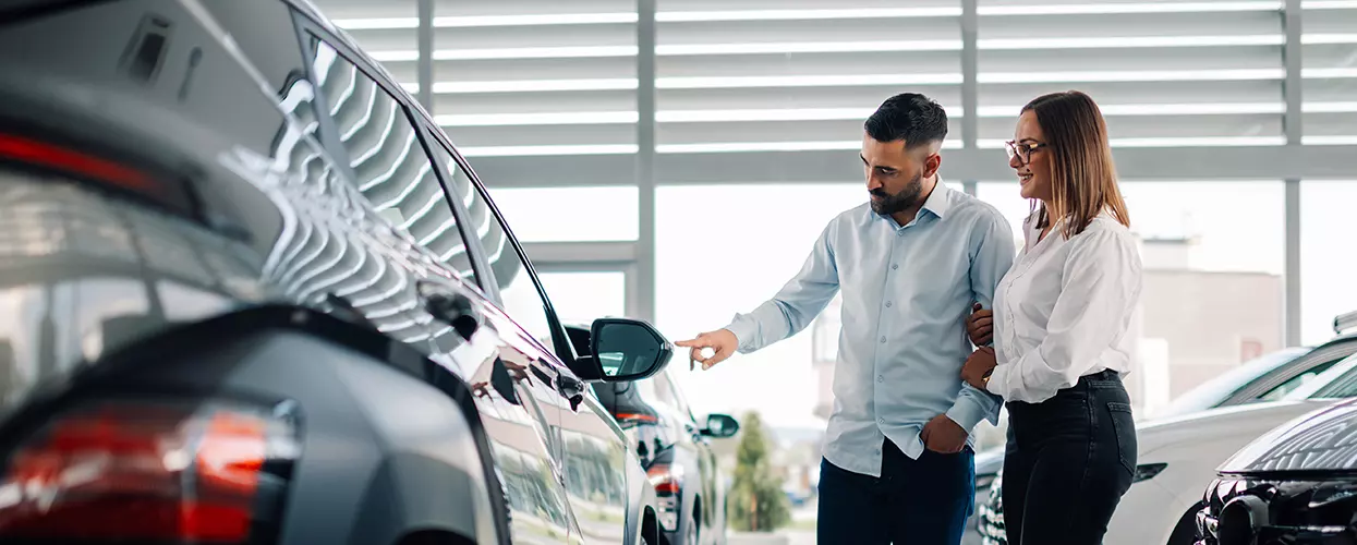 Couple looking at a new vehicle in a dealership