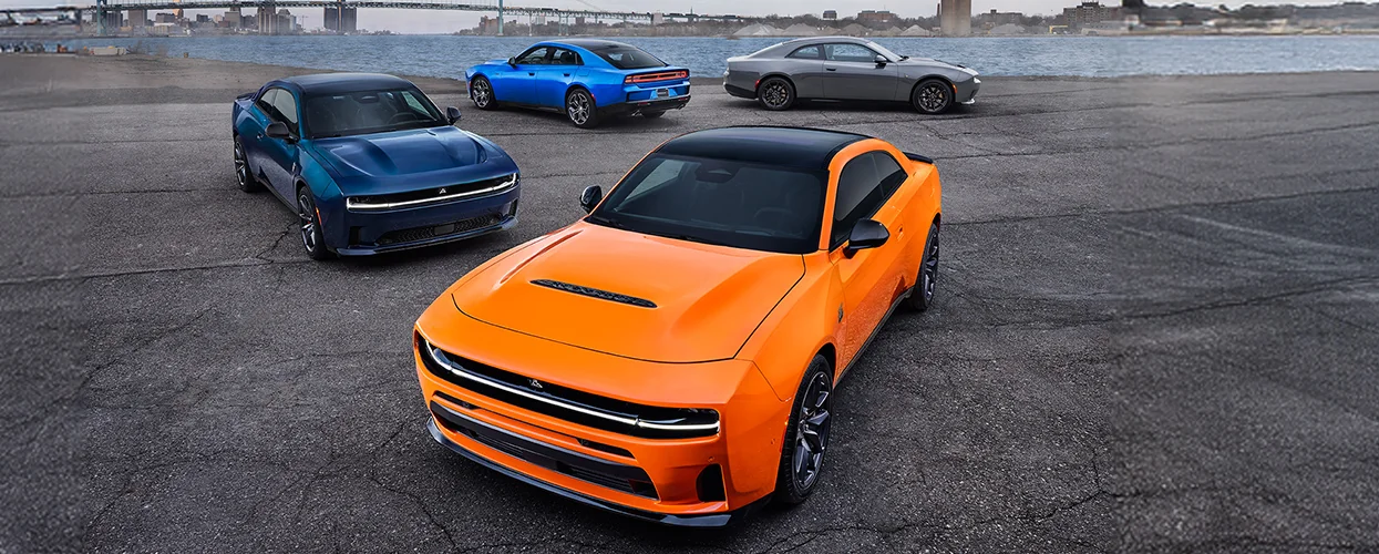Four Dodge Chargers displayed in orange, blue, and black colors, showcasing a vibrant automotive lineup.