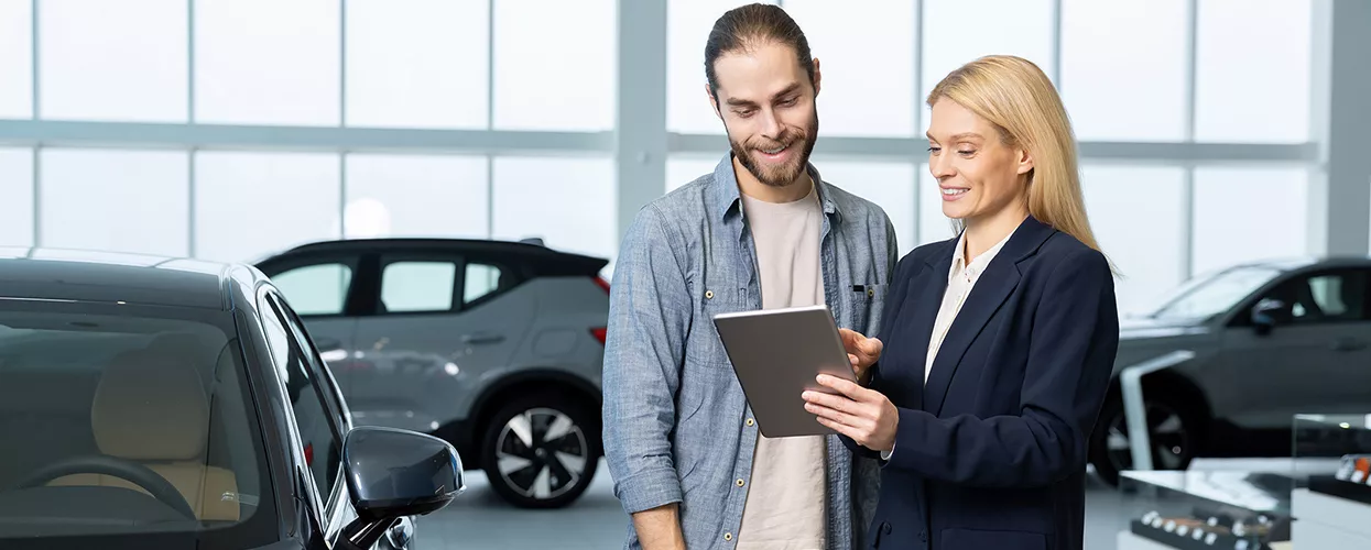 Car saleswoman showing a customer a tablet