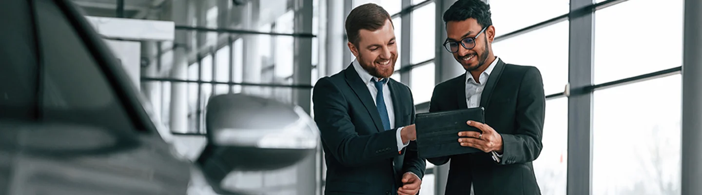 Two people looking at a tablet at a dealership