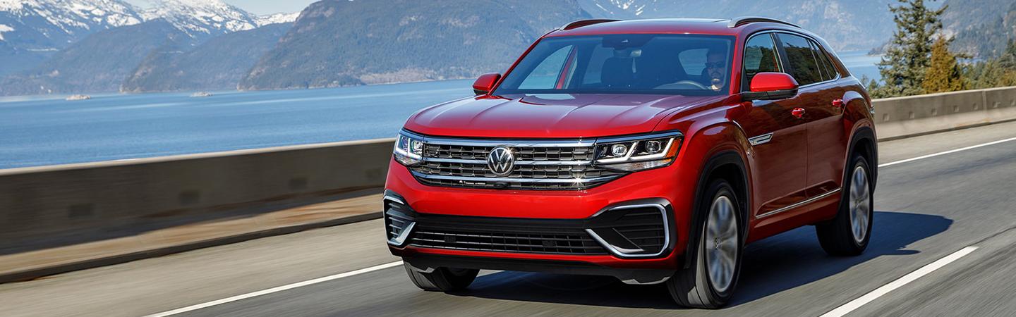 A red 2021 Volkswagen Atlas Cross Sport driving over a bridge