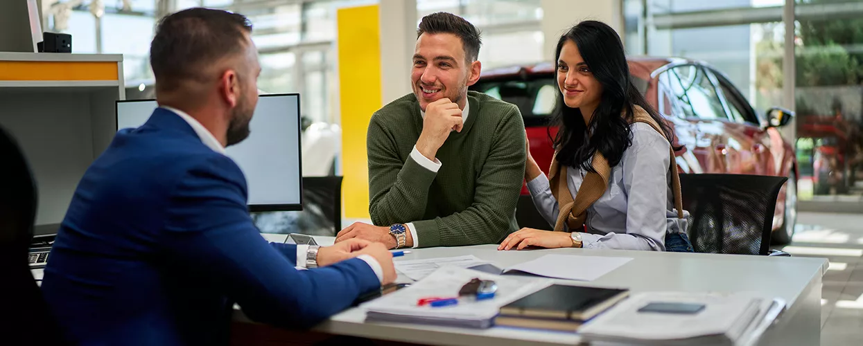 Customer reviewing BMW finance and lease paperwork with an advisor at a dealership
