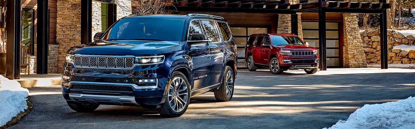 Front few of a blue 2024 Grand Wagoneer parked in front of a house