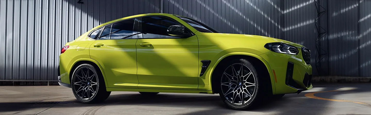 Side view of a parked yellow 2024 BMW X4
