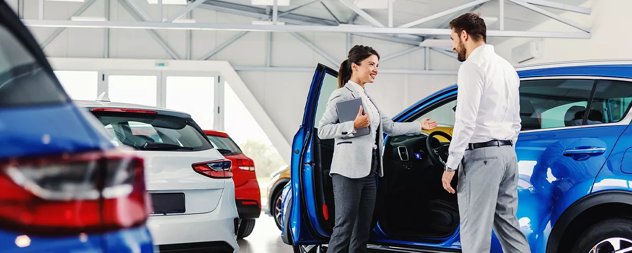 Sales person showing a customer the inside of a new BMW