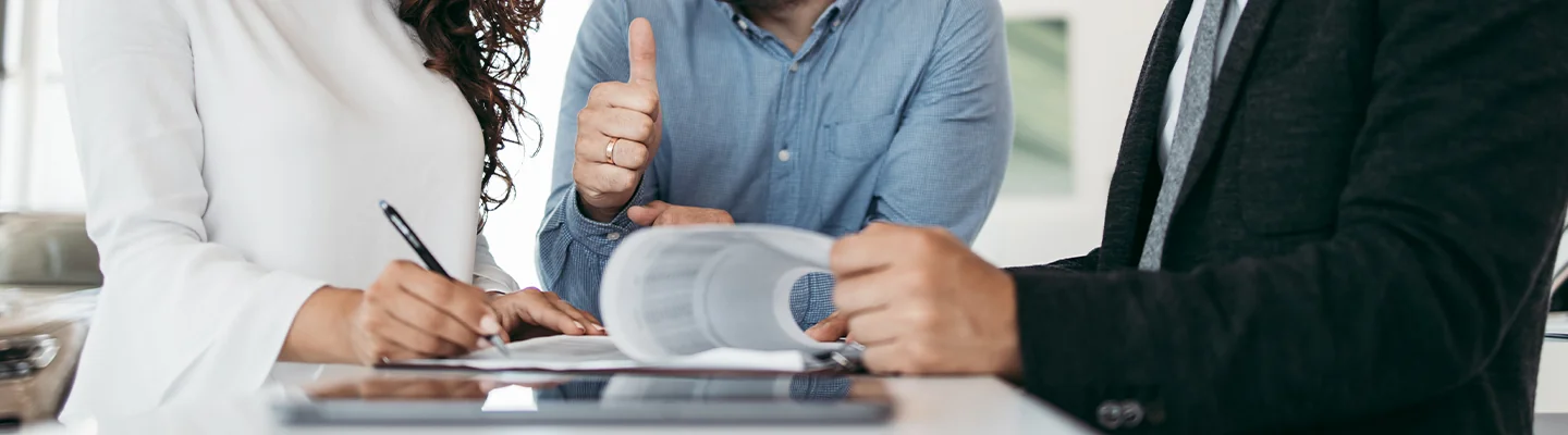 Sales person helping customers fill out paper work for financing