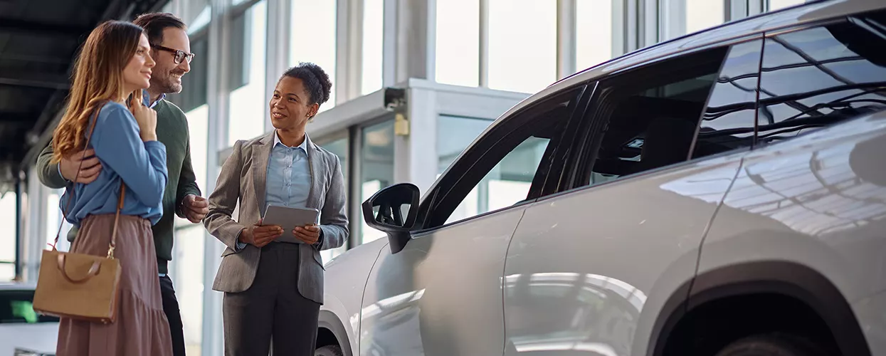 Couple looking at a new vehicle at a car dealership