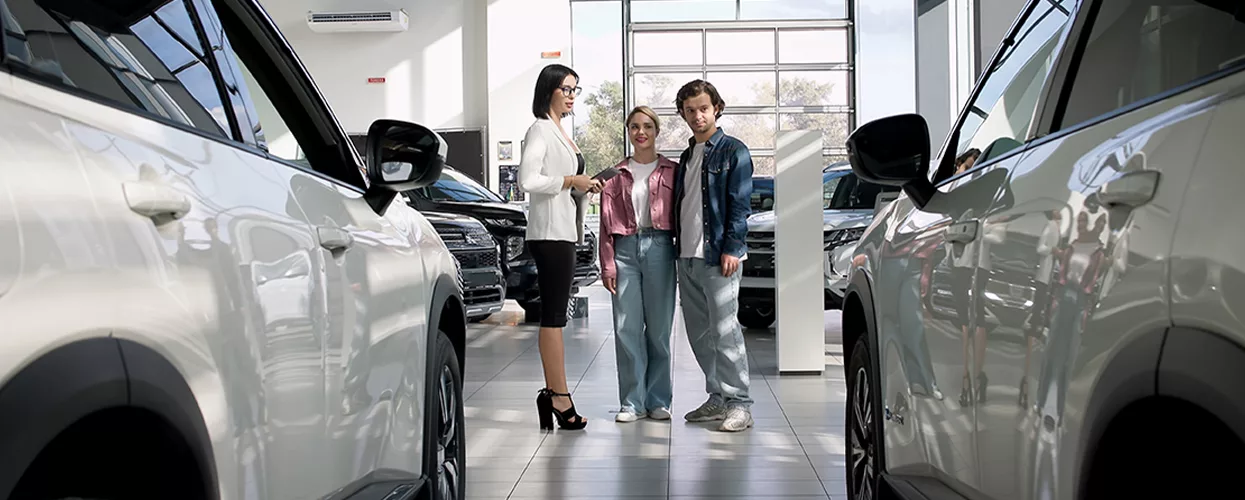 couple speaking with car salesperson in the dealership showroom
