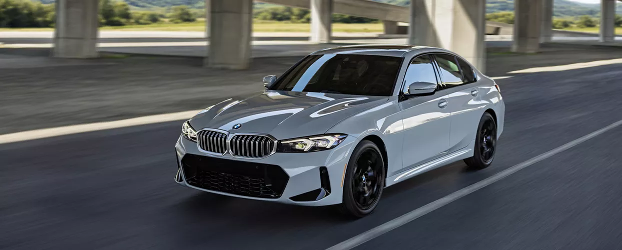 BMW 3series driving down a road