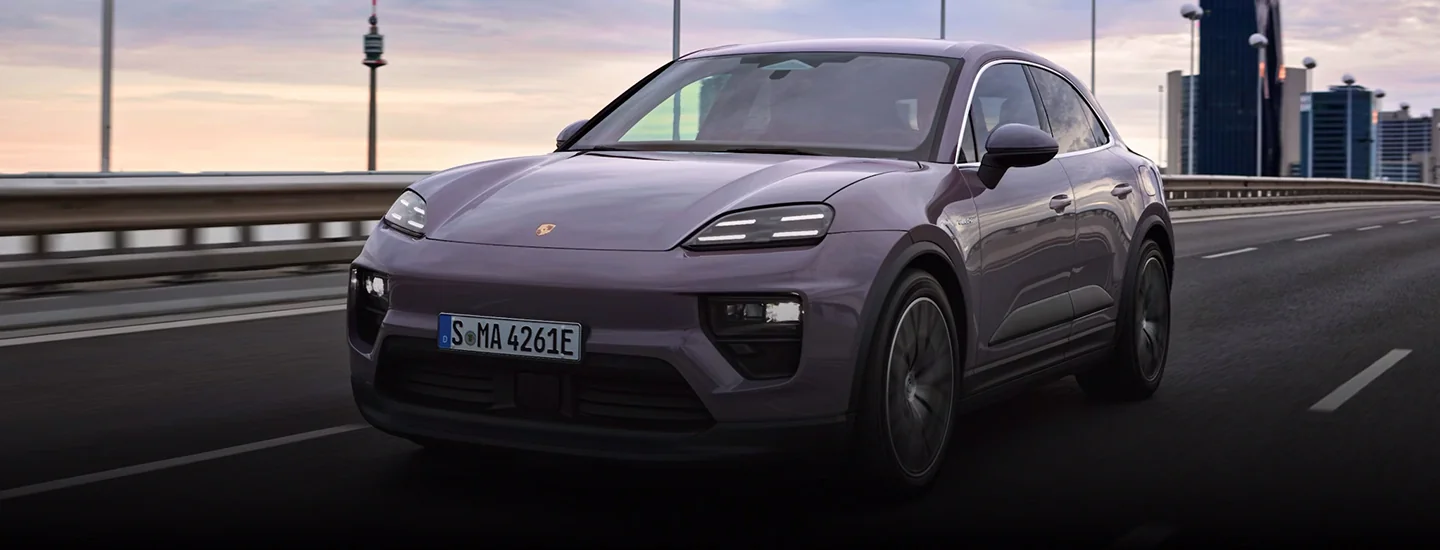 Purple 2025 Porsche Macan driving on the freeway