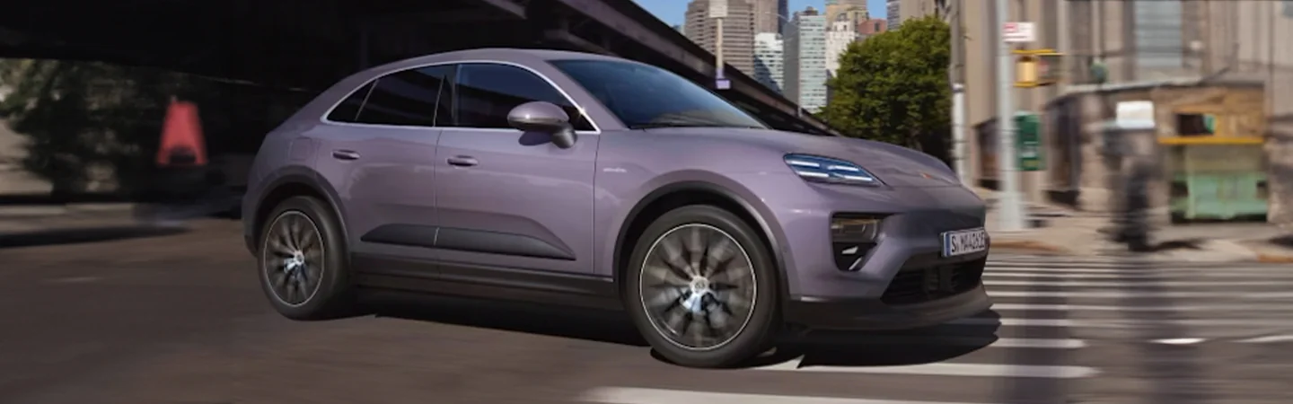 Purple 2025 Porsche Macan driving in the city