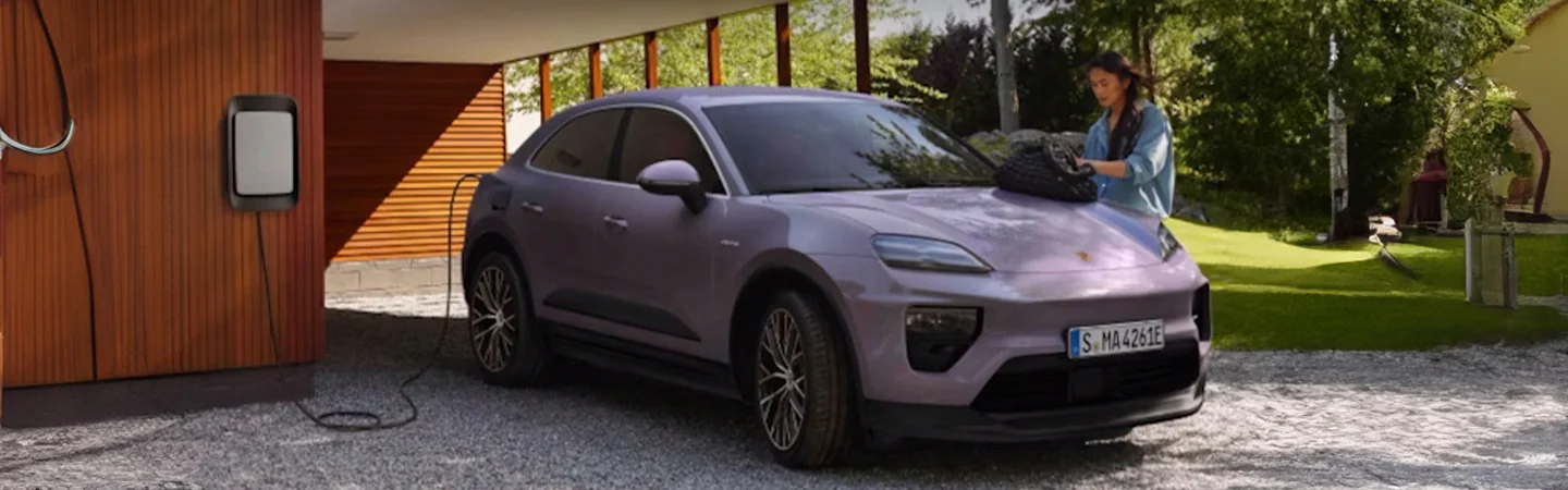 Purple 2025 Porsche Macan EV parked in the driveway charging