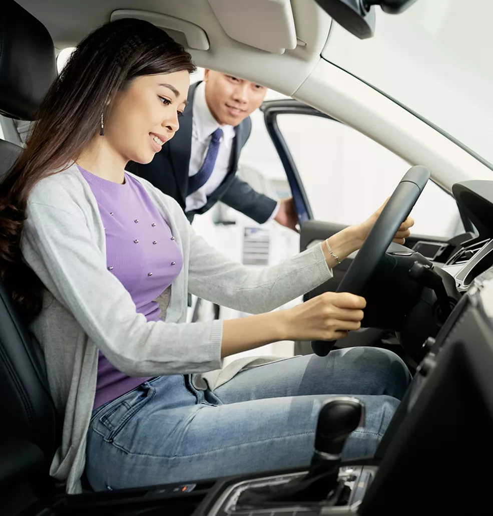 Car salesman showing a customer the inside of a new vehicle