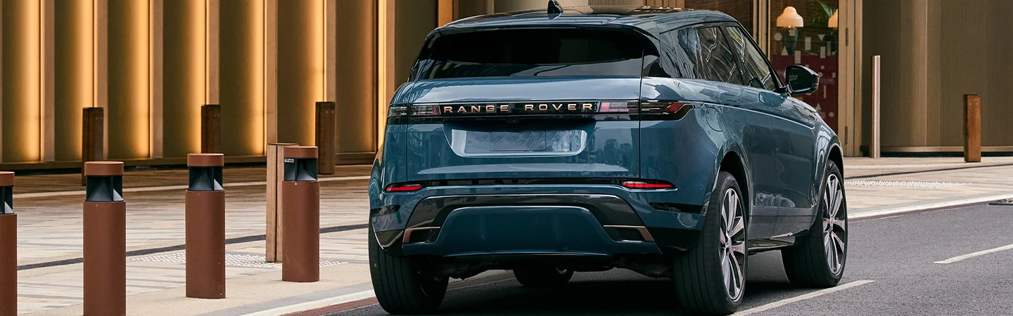 Back view of a blue 2026 Range Rover Evoque driving on a city street