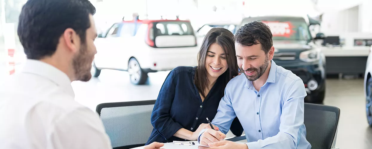 Couple talking to a car salesman about a new vehicle