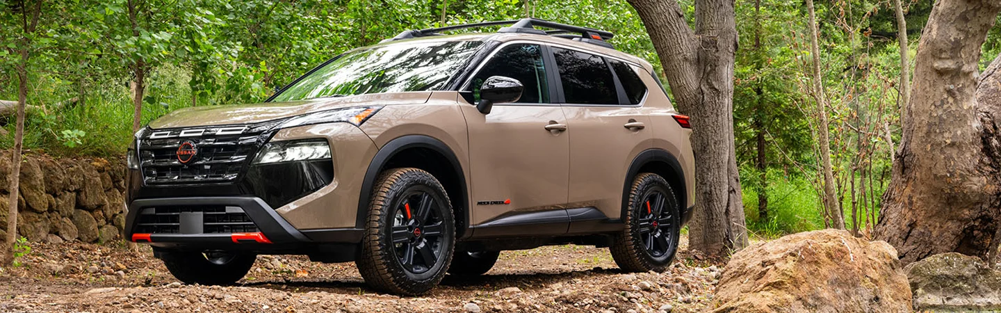 tan Nissan Rogue in forest