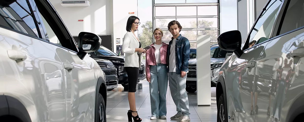 Car saleswoman showing a couple a new vehicle