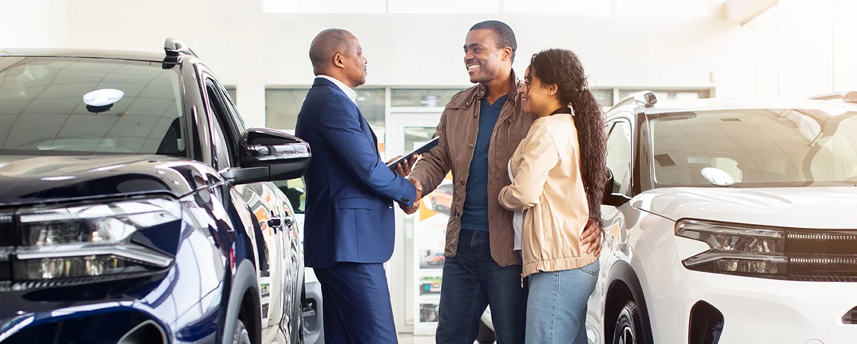 Sales person talking to customers while giving a hand shake