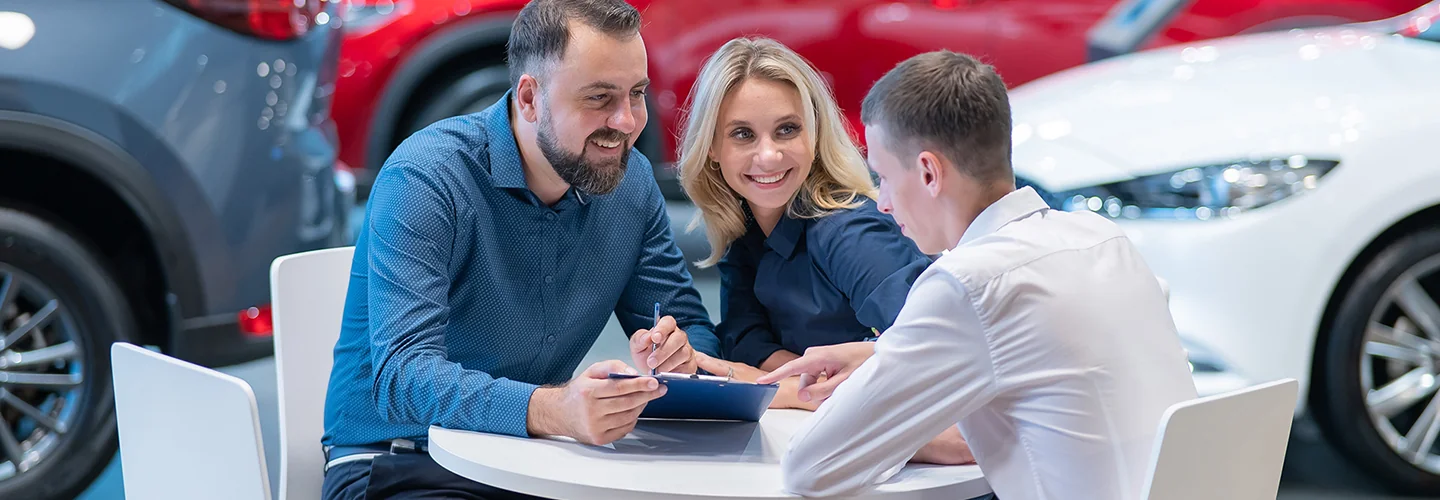People sitting at a desk with a BMW salesperson